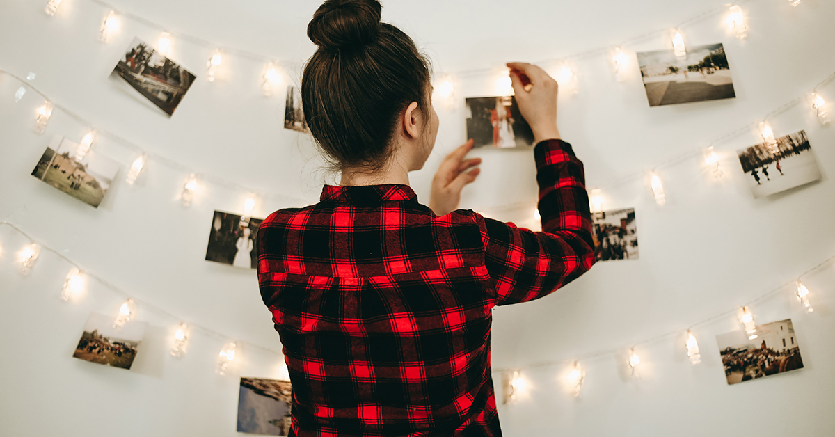 Light-coloured wall decorated with lights and pictures