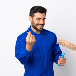 Smiling man in Royal blue shirt with a paint roller in hand